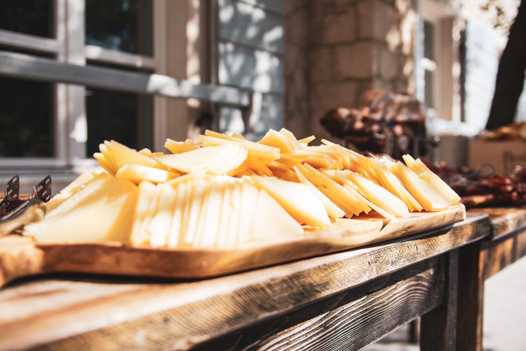 帕格岛是克罗地亚扎达尔最棒的一日游之一，外面的木桌上放着帕格奶酪片