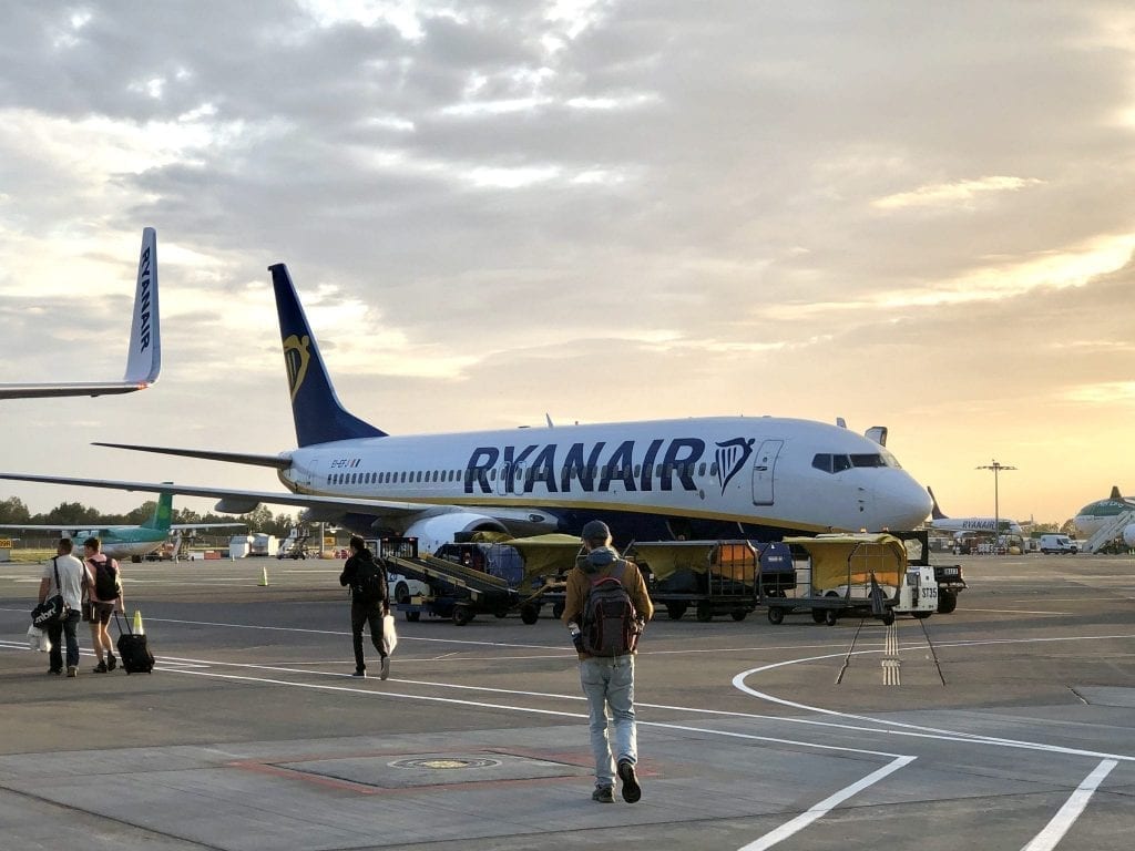 瑞安航空(Ryanair)的一架飞机停在停机坪上，人们正在登机——乘坐廉价航班时，你必须格外小心，把所有飞机上的必需品都打包好