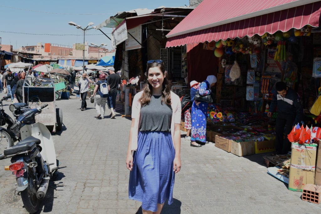 凯特站在马拉喀什麦地那，购买纪念品，这将增加摩洛哥之旅的成本，但是值得的