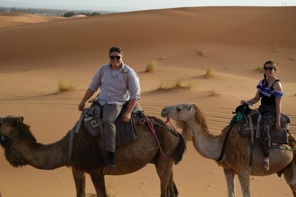 凯特·斯托姆和杰里米·斯托姆在撒哈拉沙漠骑骆驼，这是摩洛哥最昂贵的旅行之一，花的每一分钱都是值得的