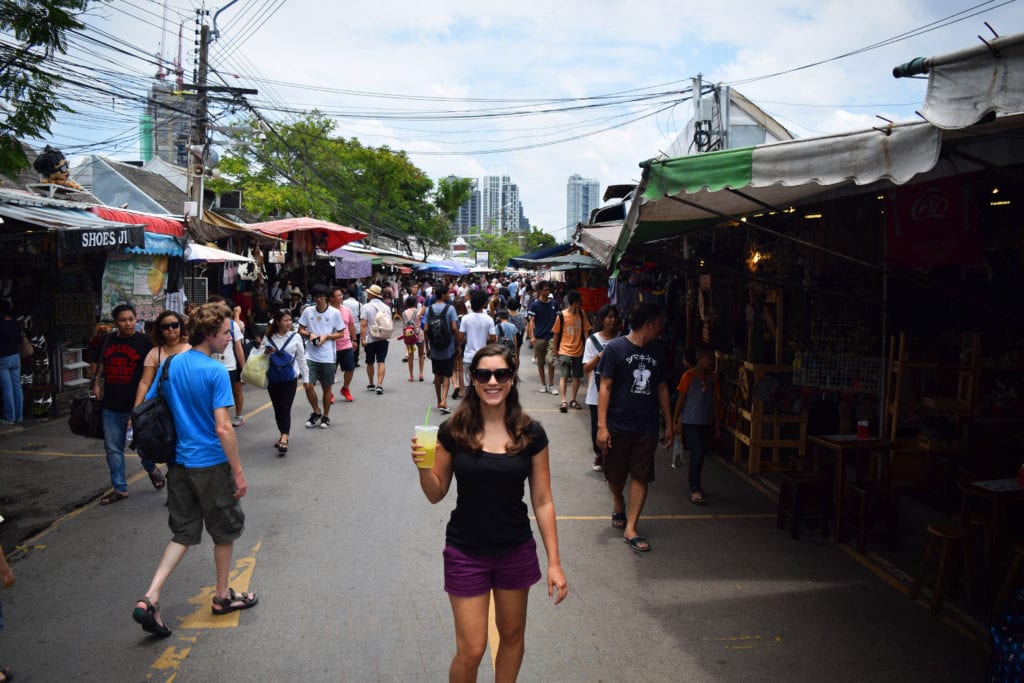 凯特风暴在chatuchak周末市场拿着百香果奶昔——我们最喜欢的曼谷旅行小贴士之一就是喝很多百香果奶昔必威体育官方登录