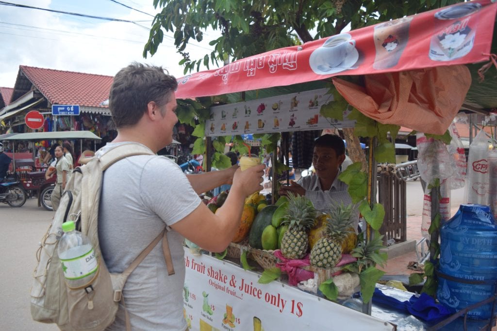 杰里米·斯托姆在柬埔寨暹粒的一个街头摊位上购买果汁