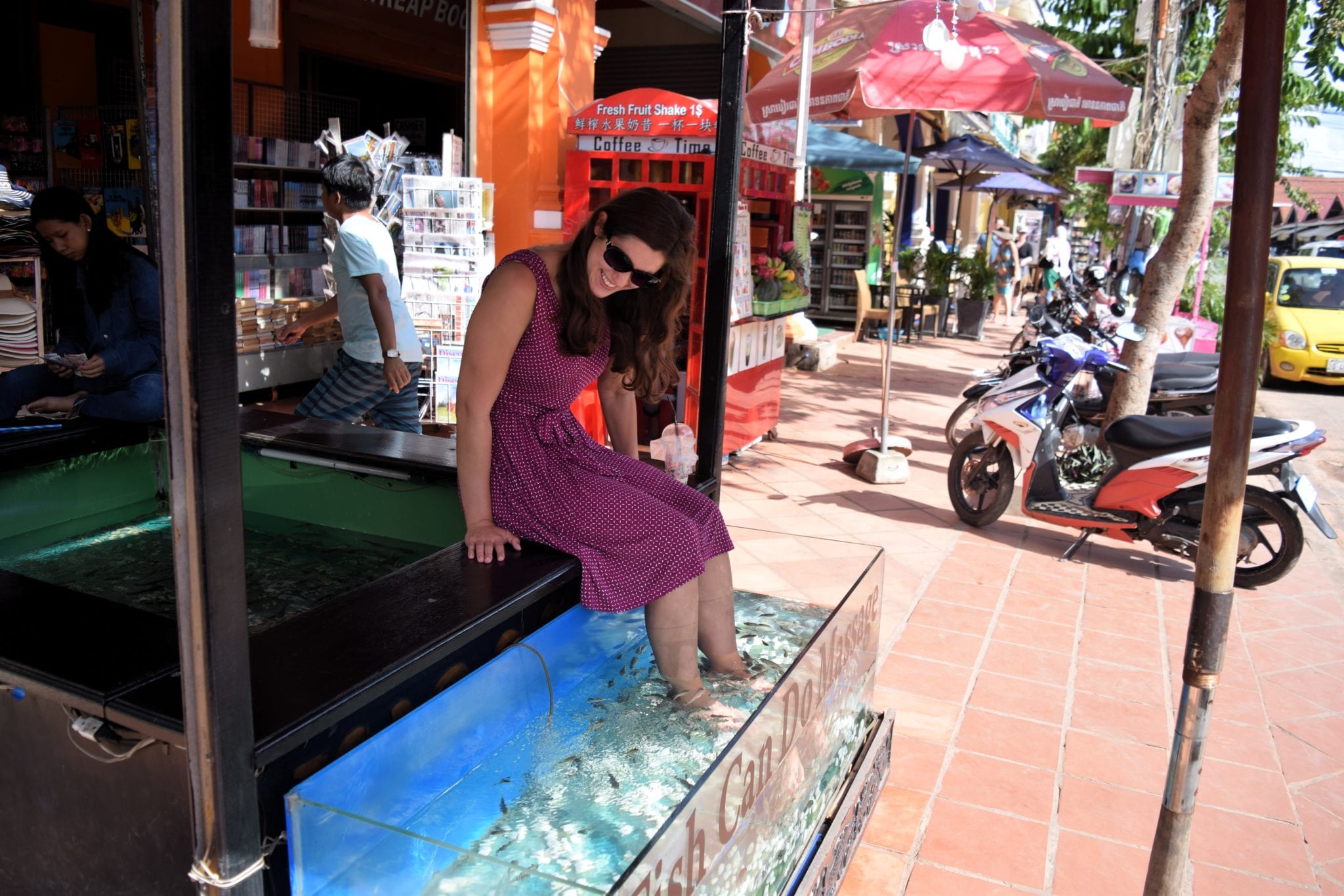 凯特风暴穿着紫色的连衣裙使用鱼水疗，是柬埔寨之旅的一小部分费用