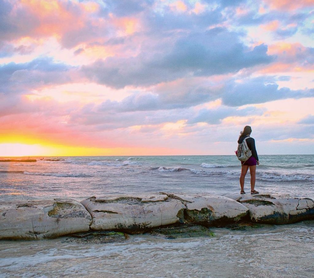 凯特·斯托姆站在墨西哥holbox岛的海滩上看日落