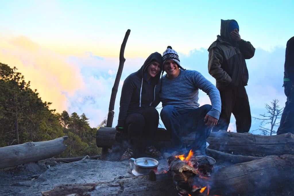 凯特·斯道姆和杰里米·斯道姆在远足完阿卡特南戈火山后坐在篝火旁
