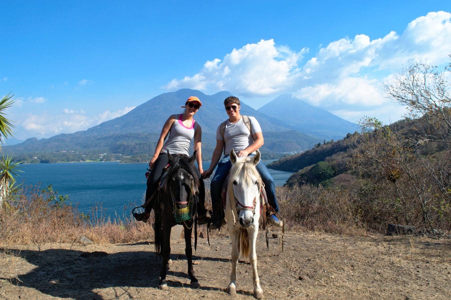 凯特·斯托姆和杰里米·斯托姆在危地马拉旅行时沿着阿提特兰湖畔骑马