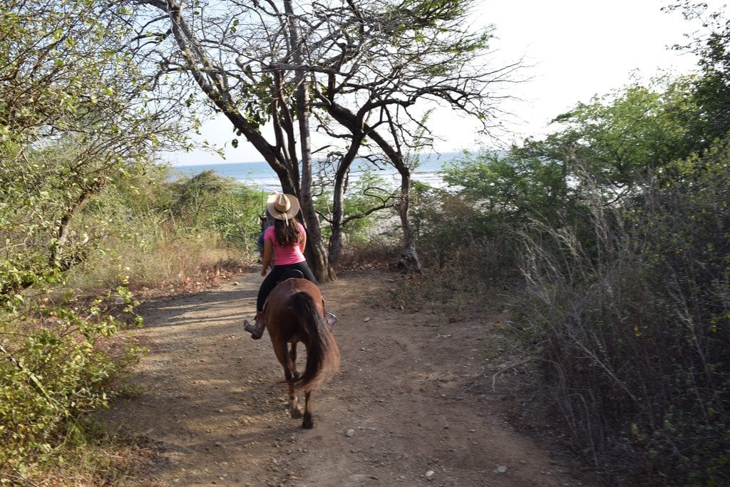 凯特·斯道姆骑着一匹棕色的马，和兰彻·奇拉玛特在尼加拉瓜骑马