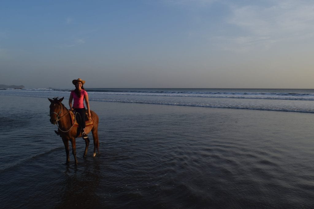 尼加拉瓜骑马人在日落的海滩上