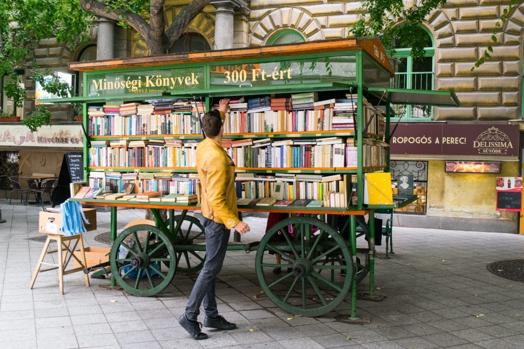 穿着黄色夹克的男子在布达佩斯的一家户外书店购物，这是一个相当便宜的欧洲旅游目的地