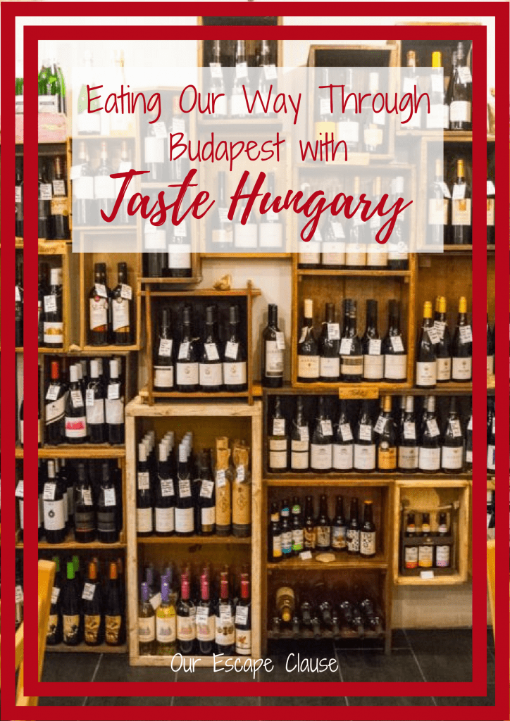 图为品酒台上出售的葡萄酒，白色底色的红色文字写着“品尝匈牙利风味，一路吃遍布达佩斯”。