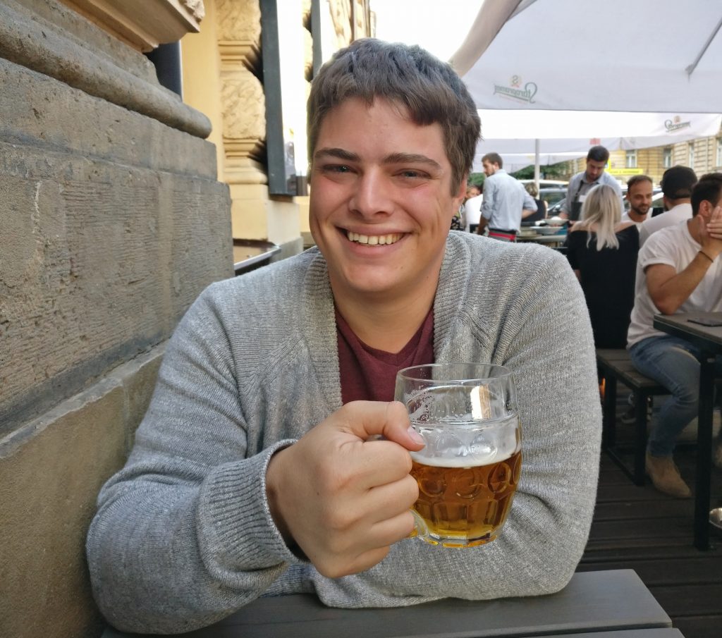 杰里米穿着灰色毛衣在捷克共和国布拉格的一家餐厅喝啤酒