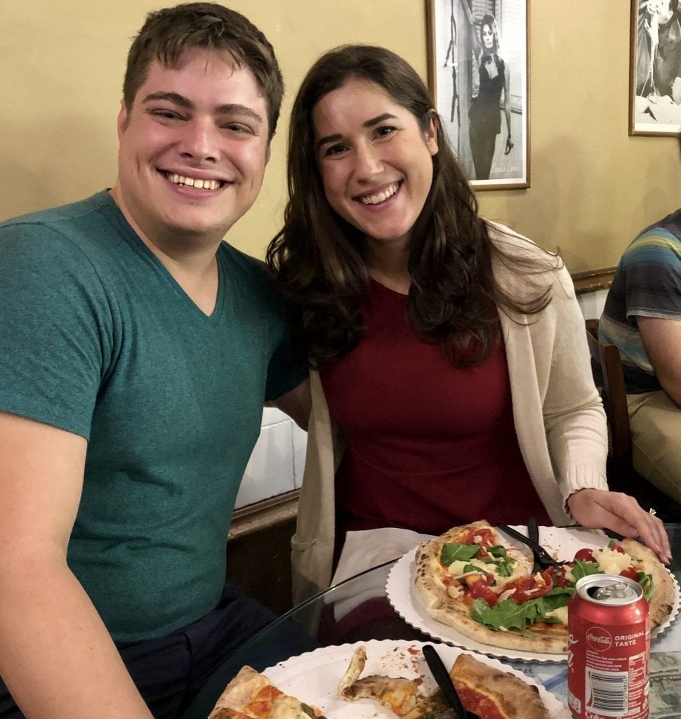 凯特·斯道姆和杰里米·斯道姆在佛罗伦萨的古斯塔披萨店，他们面前摆着切片披萨。Gusta Pizza是意大利佛罗伦萨最好的披萨店