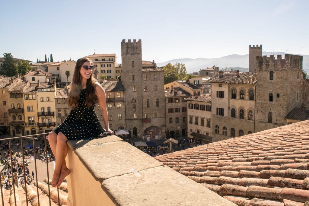 凯特·斯道姆坐在俯瞰阿雷佐的岩架上，这是从佛罗伦萨出发的最好的一日游之一
