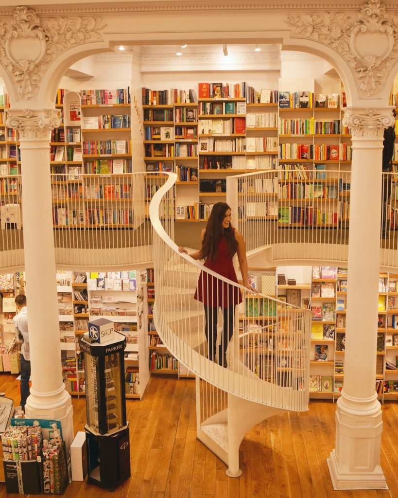 在罗马尼亚布加勒斯特的一家书店的楼梯上，凯特身穿红色连衣裙