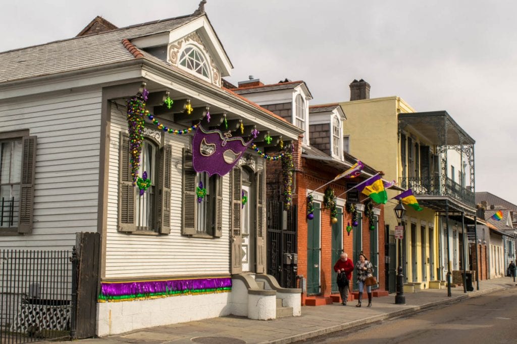 在新奥尔良的一个长周末假期中，在法国区，一排排彩色的房子前面装饰着狂欢节的装饰。