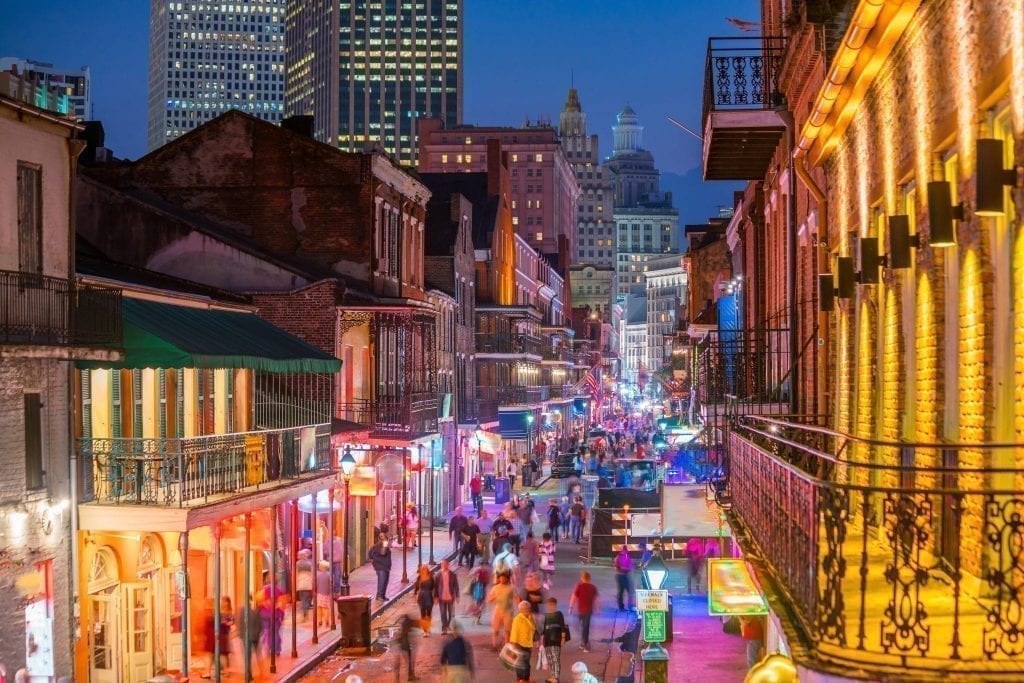 夜晚的新奥尔良法国区街道，酒吧的霓虹灯点亮了它——在新奥尔良的3天行程中，不要错过任何体验新奥尔良传奇夜生活的机会!