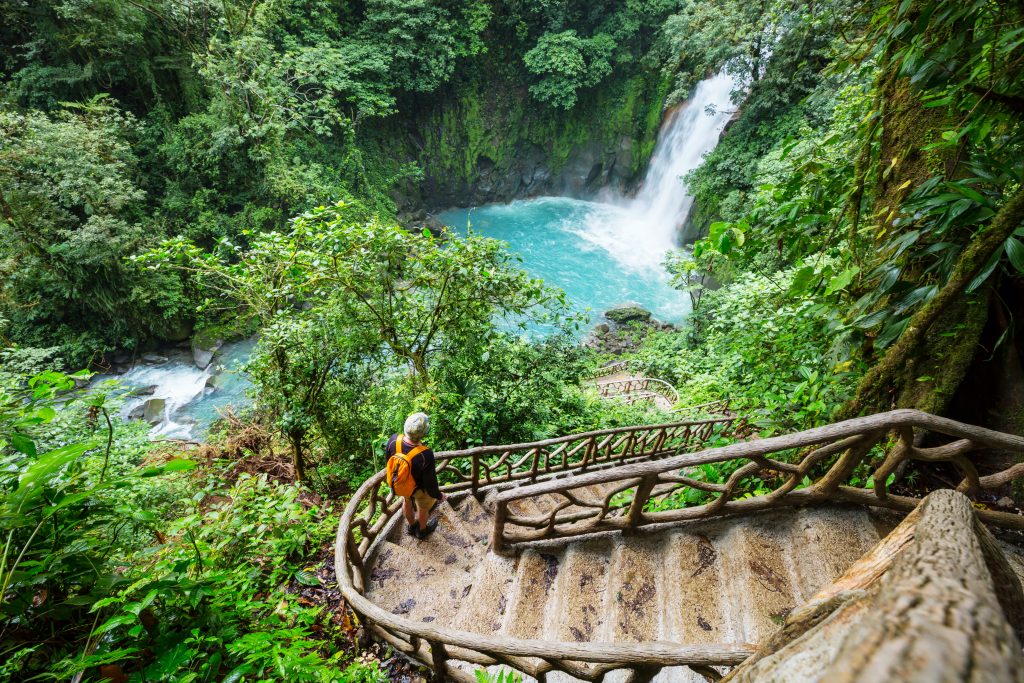 在哥斯达黎加，一名女子走下楼梯走向瀑布