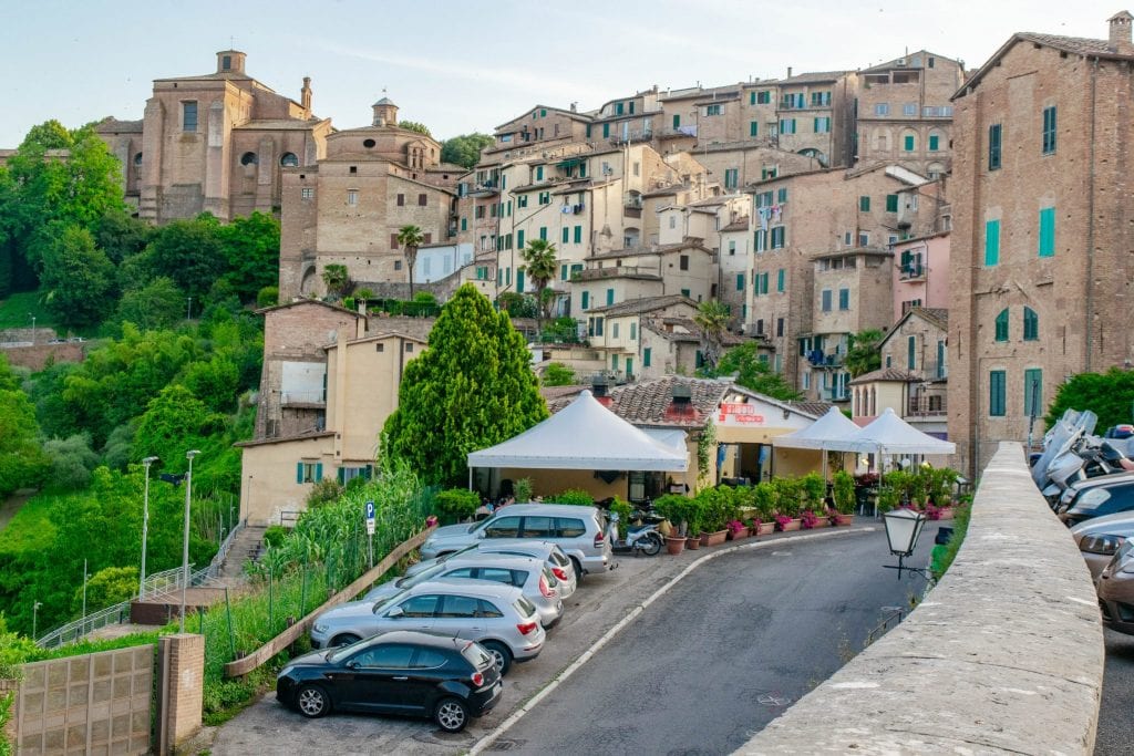 汽车停在意大利锡耶纳外——在托斯卡纳自驾游时，把车停在历史悠久的市中心外是常态!