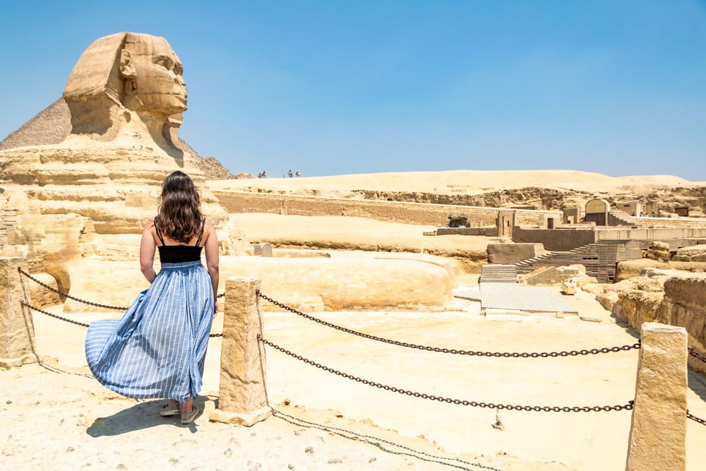 凯特在埃及开罗停留了很长时间，她穿着蓝色裙子站在狮身人面像前