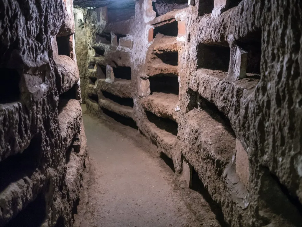 underground catacombs of rome italy with niches carved into tufa rock