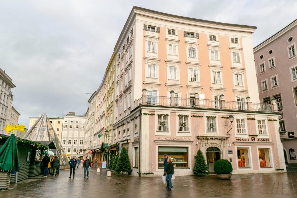 阴天，奥地利萨尔茨堡的粉色建筑，左边是圣诞市场