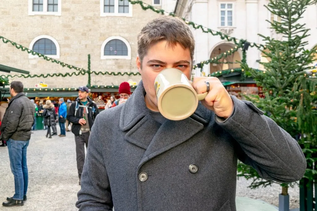 杰里米在访问欧洲的圣诞节行程中，在萨尔茨堡圣诞市场用一个大杯子喝水