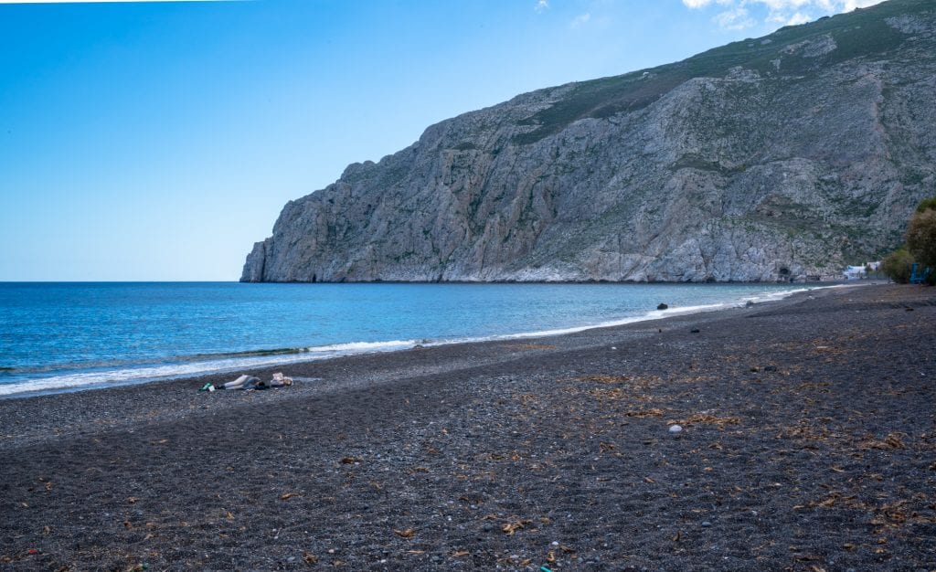 希腊卡马里的黑色沙滩，背景是悬崖