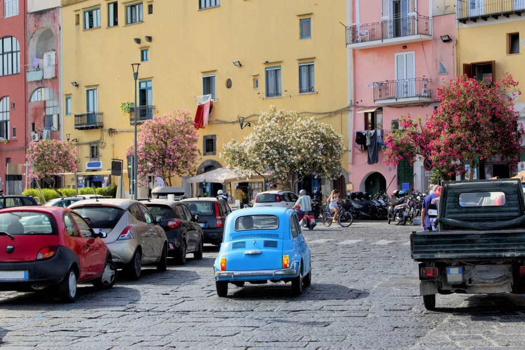 在意大利罗马，蓝色的菲亚特与其他几辆车一起驶过一个区域