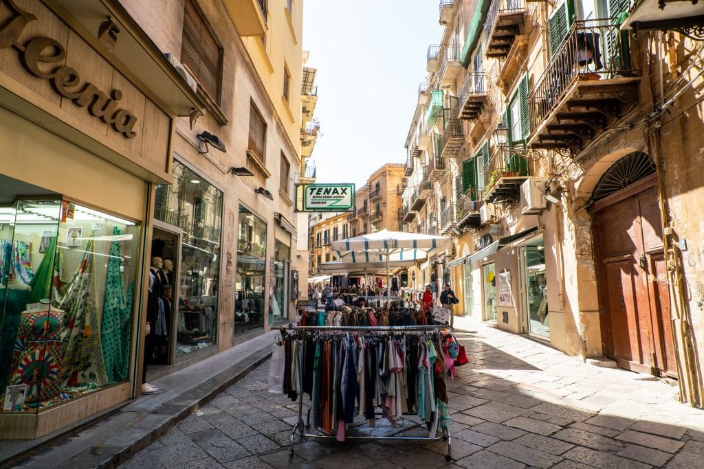 西西里岛巴勒莫大街，外面有卖衣服的架子