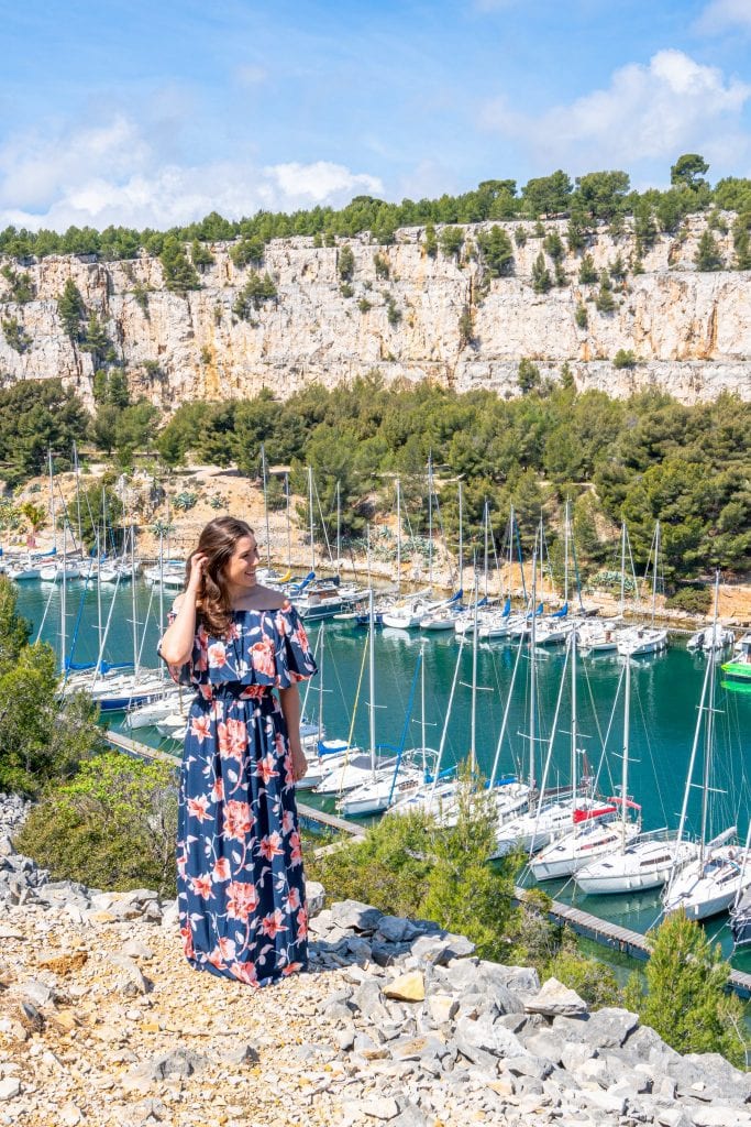 Woman in floral dress standing in front of Port Miou near Cassis Provence France