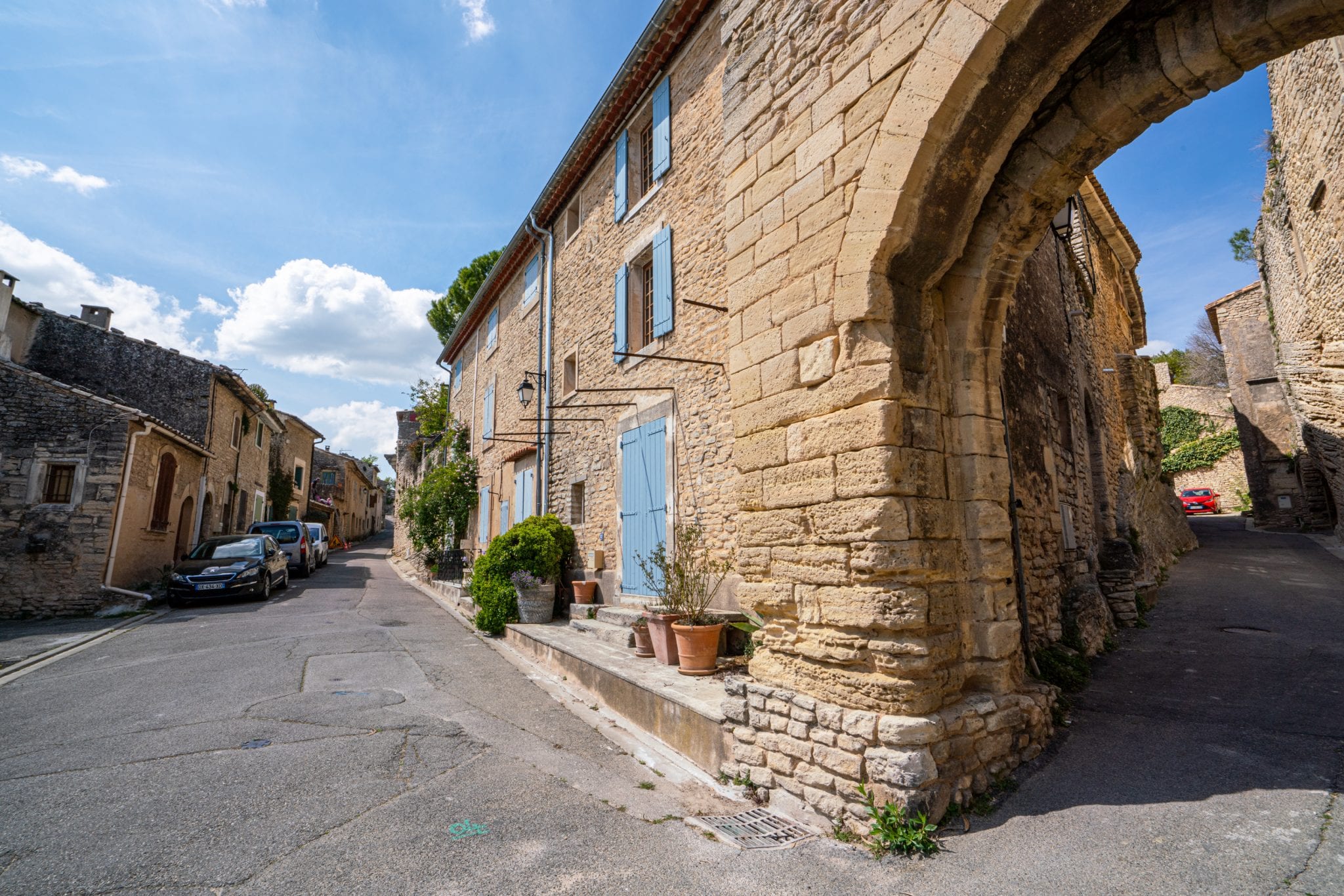 位于法国古尔特的街道，右边有一座石砌建筑，有蓝色的百叶窗