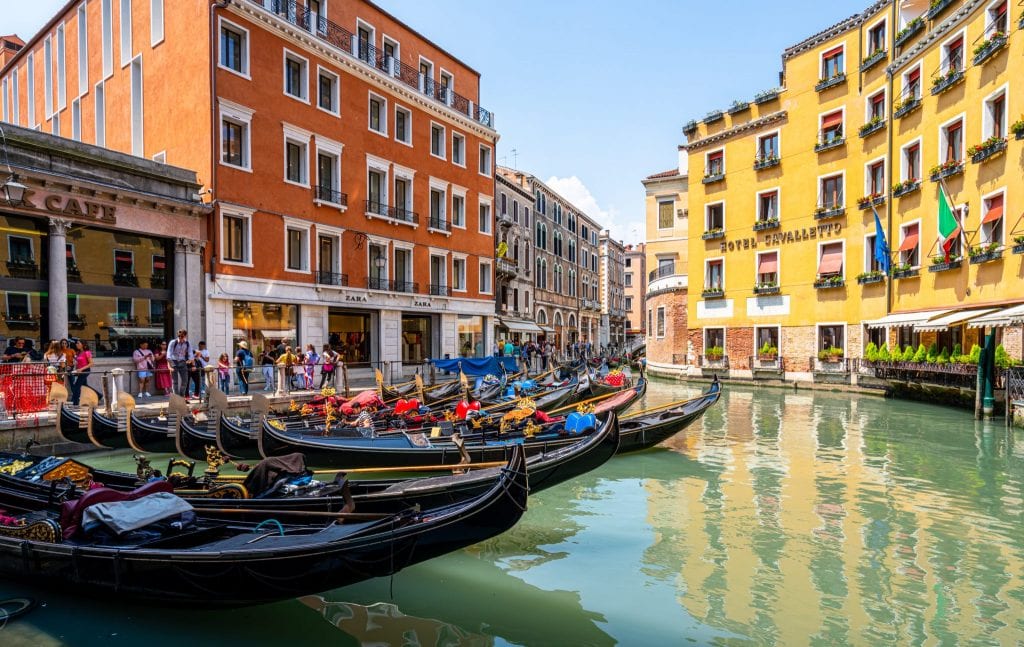 一系列的贡多拉停在威尼斯的一条运河里——关于意大利最有趣的事实之一是，现在这个城市里的贡多拉比过去少得多