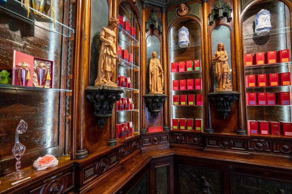 威尼斯商人旗舰店内饰。墙壁上摆放着红色的香水瓶子，商店里装饰着女性的小石像。