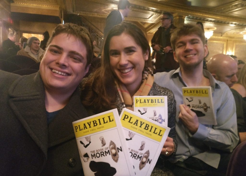 凯特、杰里米和他们的朋友迈克尔在百老汇演出，手里拿着《摩门经》的节目单