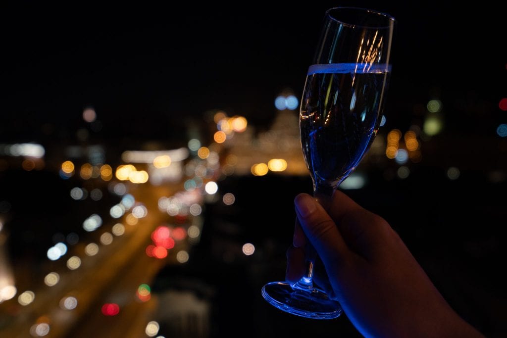 夜晚在马德里繁忙的街道上举着一杯普罗塞克酒