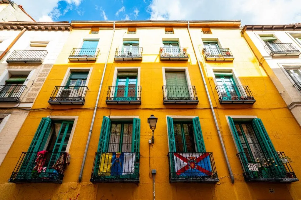 西班牙马德里拉丁区的彩色黄色建筑，带有绿色百叶窗