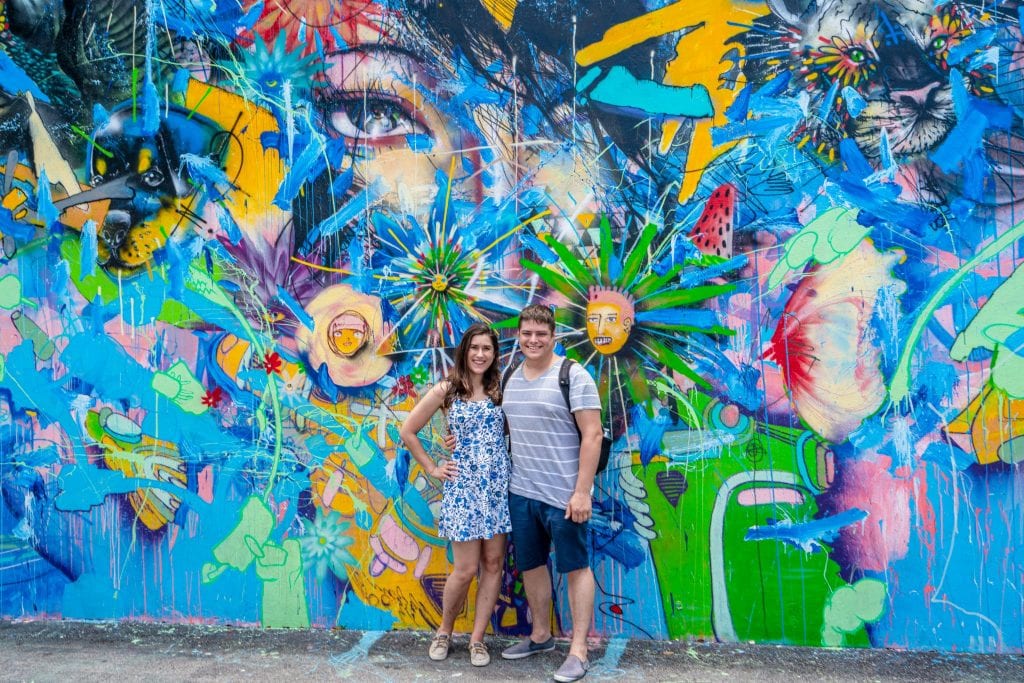 凯特和杰里米站在迈阿密温伍德的一幅色彩斑斓、大部分是蓝色的壁画前