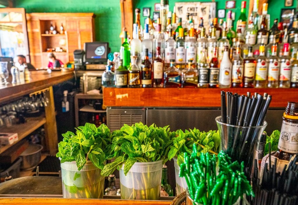 迈阿密小哈瓦那的Ball & Chain酒吧:镜头的前景是新鲜的薄荷，后面是一个满是存货的酒吧。