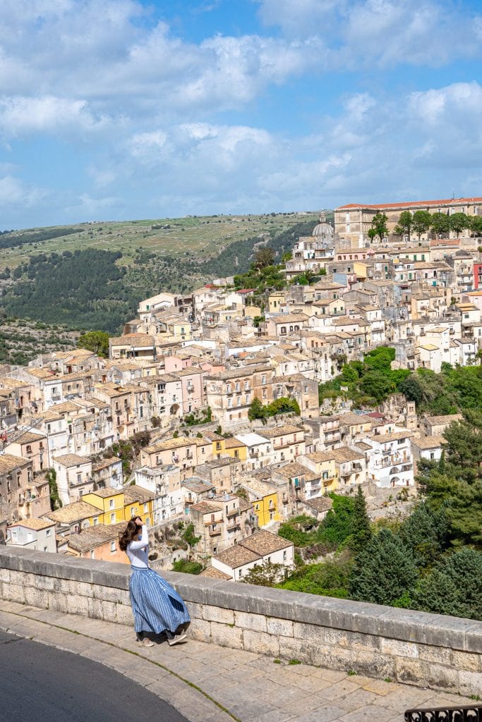 凯特·斯道姆穿着蓝色裙子，从拉古萨Superiore俯瞰拉古萨伊尔巴，这是西西里岛10天行程中最美的景色之一