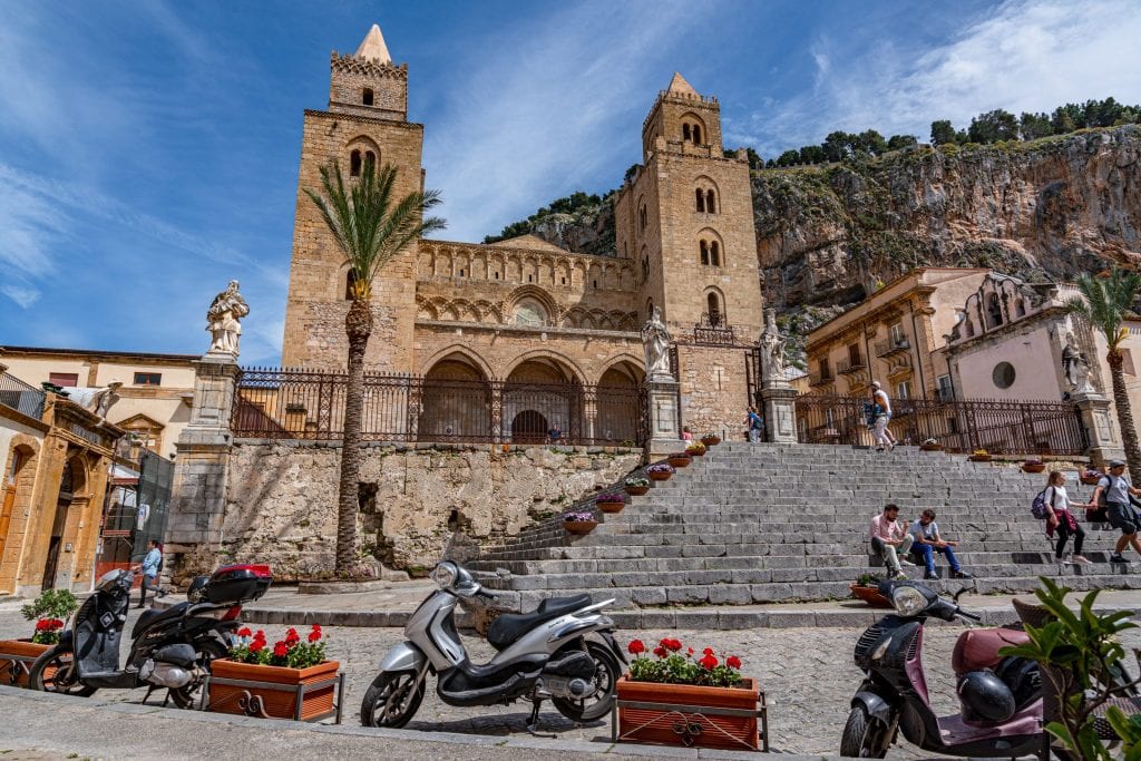 Cefalu大教堂前停着一辆小型摩托车，这是西西里自驾游行程中最值得一看的景点之一