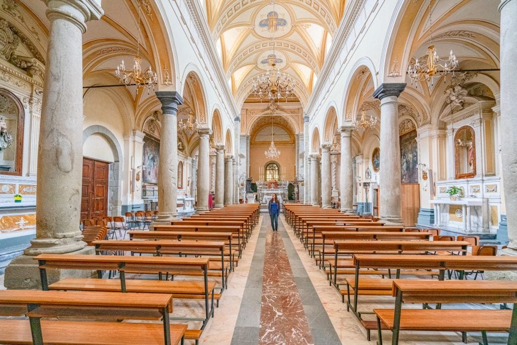 身穿蓝色衬衫的凯特·斯道姆站在西西里岛弗兰卡维拉的一座教堂里