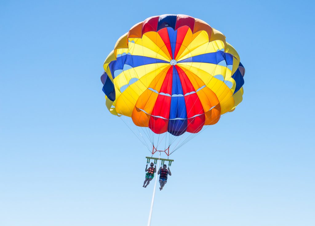 两个人在一个彩色的滑翔伞上滑翔