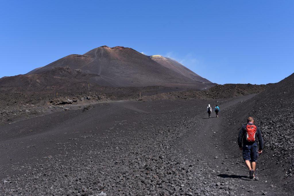 人们在西西里岛贫瘠的埃特纳火山徒步旅行