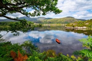 爱尔兰基拉尼国家公园湖中的划艇照片——在整理你的爱尔兰打包清单时，一定要准备好各种天气!