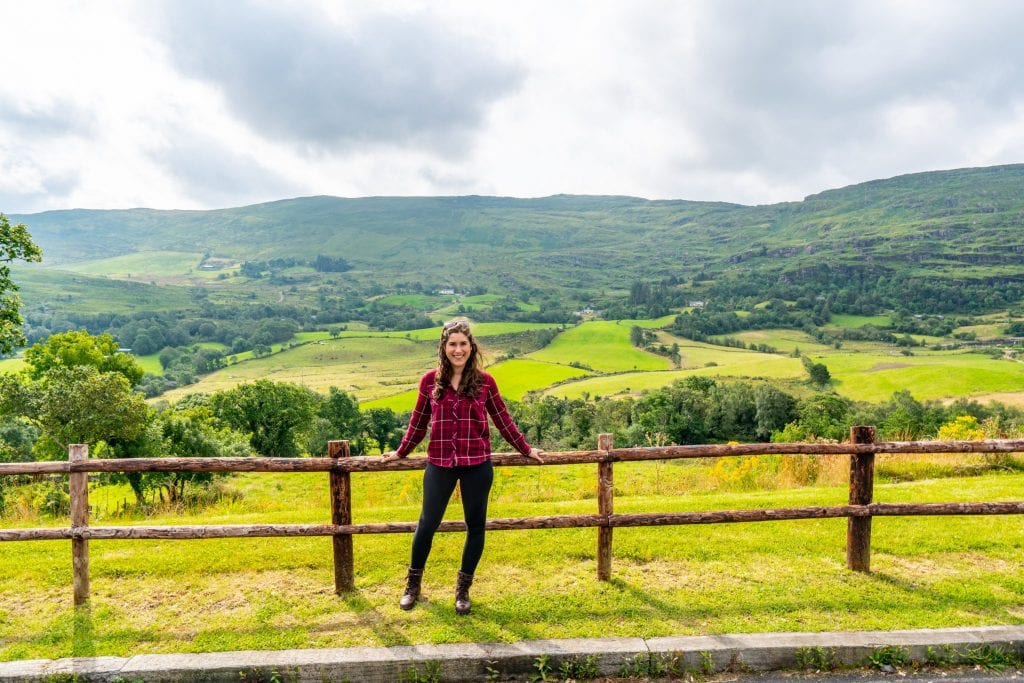 凯特·斯道姆站在一处有爱尔兰乡村背景的分层栅栏旁——在爱尔兰自驾游中可以发现很多这样的东西!