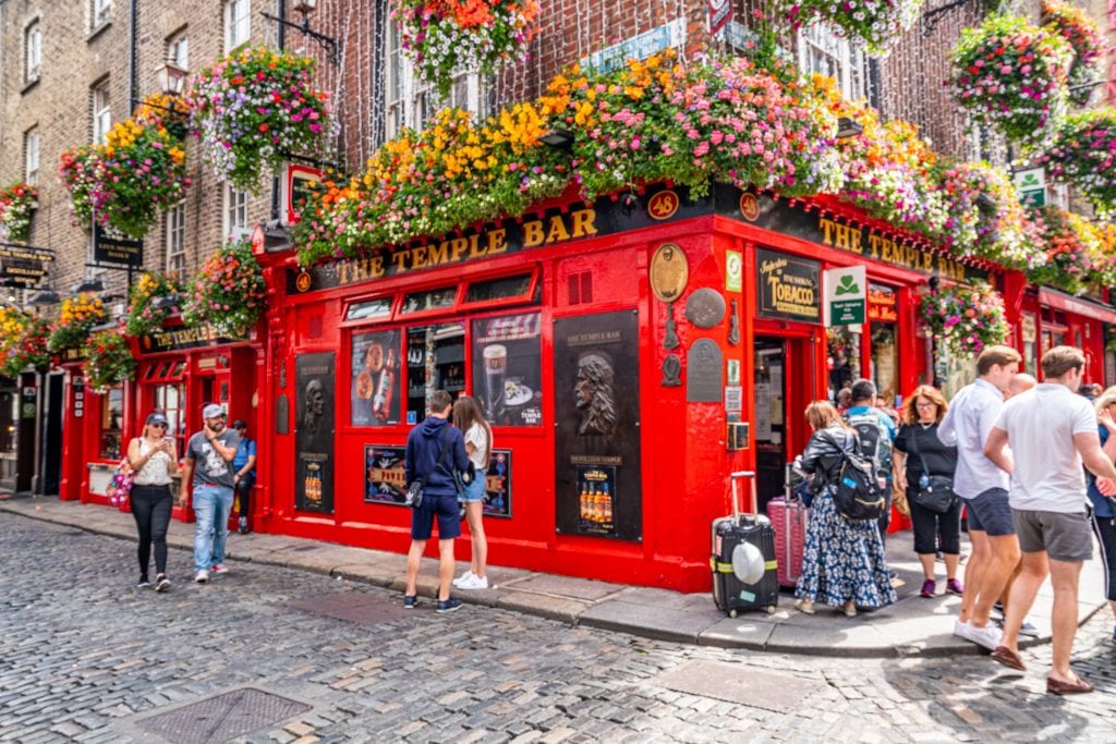 Temple Bar as seen on a summer day, with flowers over the entrance to the bar--an iconic bar, it's worth at least stopping by during a 2 day Dublin itinerary.
