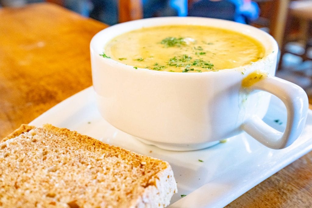 在爱尔兰用白碗盛的一杯汤，前景是一片爱尔兰黑面包