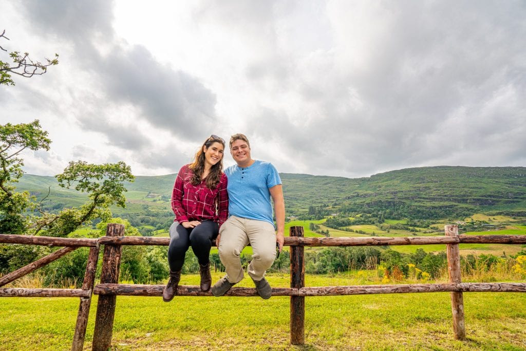 凯特·斯道姆和杰里米·斯道姆在爱尔兰自驾游时坐在爱尔兰的分层栅栏上
