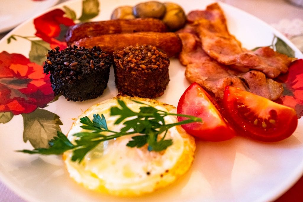 完整的爱尔兰早餐，盘子中央有黑白布丁——在爱尔兰寻找最好的食物时，一定要尝试两种布丁!