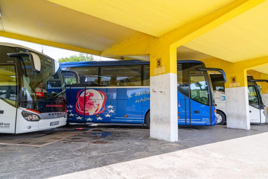 特罗吉尔汽车站的黄色雨棚下停着一群白蓝相间的公共汽车——乘坐公共汽车几乎肯定是你10天克罗地亚之旅的一部分!